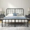 A black metal bed frame with a white mattress and blue bedding is shown in a bedroom setting with two nightstands and lamps. Produktbild-Vorschau