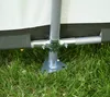 A close-up view of the base of a tent or shelter, showing the metal pole and its connection to the ground. Produktbild-Vorschau