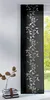 A black panel curtain with a white vine pattern is shown hanging in front of a window. To the left, a stack of books and a vase with dried leaves are visible. Produktbild-Vorschau