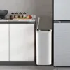 A modern kitchen scene with white cabinets, a stainless steel trash can, and a refrigerator. Podgląd zdjęcia produktu