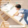 A young child is playing on a wooden climbing structure indoors. Produktbild-Vorschau
