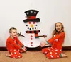 Two children in pajamas are posing with a large snowman decoration on a wall. Náhľad obrázku produktu