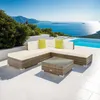 A rattan lounge set with cushions and a coffee table is placed on a patio overlooking the ocean and a swimming pool. Voir les images du produit