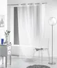 A sheer white curtain hangs in a bright room, with a transparent chair and a small gray cabinet visible. Produktbild-Vorschau