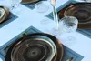 A table setting with plates, glasses, and a candlestick. Podgląd zdjęcia produktu