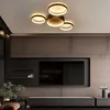 A modern living room with a large TV and a stylish ceiling light. Voir les images du produit
