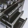 A close-up view of the drawers and control knobs of a black and silver outdoor kitchen appliance. Náhled obrázku produktu