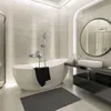 A modern bathroom with a freestanding bathtub, a wall-mounted faucet, and a round mirror above a vanity. Podgląd zdjęcia produktu