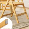 Close-up view of the leg and frame of a wooden folding chair, highlighting its construction and a non-slip footpad. Podgląd zdjęcia produktu