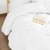 A white comforter is laid out on a bed with a book resting on it. Produktbild-Vorschau