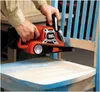 A person is using a belt sander to sand a wooden chair. Anteprima dell’immagine prodotto