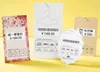 Three clothing price tags with washing instructions and barcodes displayed on a yellow background. Podgląd zdjęcia produktu