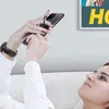 A woman is lying on a couch, holding a smartphone with a ring holder attached. Náhled obrázku produktu