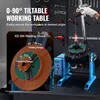 A welding positioner with a workpiece being welded, set against a workshop background with tools on the wall. Produktbild-Vorschau