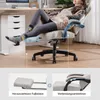 A person is relaxing in a gaming chair with their feet up on a footrest. The image also includes close-ups of the footrest and armrests. Náhled obrázku produktu