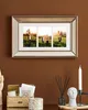 A framed collage of three family photos hangs on a brown wall above a desk with decorative items. Podgląd zdjęcia produktu