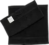 Two black towels are shown, one folded on top of the other. Produktbild-Vorschau