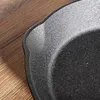 A close-up view of a cast iron pan on a wooden floor. Produktbild-Vorschau