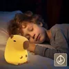 A child sleeping in bed next to a glowing capybara-shaped night light. Podgląd zdjęcia produktu
