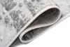 A close-up view of a rolled-up rug, showing the texture and edge binding. Náhled obrázku produktu