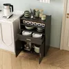 A kitchen cart filled with dishes and kitchenware, next to a countertop with a kettle. Náhled obrázku produktu