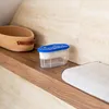 A dehumidifier sits on a wooden shelf next to a woven basket and a white cloth. Voir les images du produit