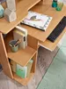 A close-up view of a wooden computer desk with various items on it, including books, a keyboard, and decorative objects. Anteprima dell’immagine prodotto