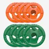 A set of orange and green weight plates stacked on a white background. Produktbild-Vorschau