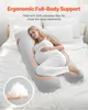 A pregnant woman is lying on a bed, using a U-shaped pregnancy pillow. Produktbild-Vorschau