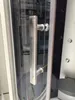 A close-up of a shower cabin door handle and part of the cabin interior. Anteprima dell’immagine prodotto