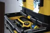 A close-up view of a yellow and black Stanley toolbox with various tools inside, including a tape measure and a screwdriver. Voir les images du produit