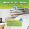 A close-up view of a bed with bedding, featuring marketing text and icons. Produktbild-Vorschau