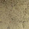 A close-up, overhead view of a granular substance, likely animal feed or soil, with small pebbles and organic matter mixed in. Voir les images du produit