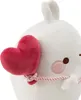 A close-up of a white plush toy with a red heart balloon tied to its side with a pink string. Produktbild-Vorschau