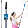 A woman is painting a wall with a roller attached to a telescopic pole. Produktbild-Vorschau