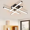 A modern ceiling light fixture with multiple arms and LED lights, mounted on a white ceiling. Voir les images du produit