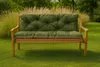 A green bench cushion is placed on a wooden bench in a garden setting. Produktbild-Vorschau
