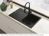 A black kitchen sink with a faucet is shown on a countertop next to a window. Anteprima dell’immagine prodotto