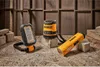 Three DeWalt tools are arranged on a wooden surface with a wooden wall in the background. Podgląd zdjęcia produktu