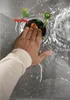 A hand is shown reaching into a kitchen sink with a garbage disposal unit, surrounded by chopped vegetables. Produktbild-Vorschau