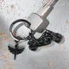A close-up shot of a motorcycle keychain and a key on a textured gray surface. Produktbild-Vorschau
