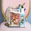A miniature dollhouse with a spiral staircase and multiple levels, decorated with plants and furniture. Anteprima dell’immagine prodotto