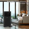 A portable air conditioner is placed in a modern living room with large windows overlooking a city skyline. Voir les images du produit