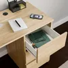 A close-up view of a desk with an open drawer, showing office supplies and a book. Náhled obrázku produktu
