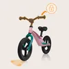 A pink balance bike with teal accents is shown against a light beige background. Graphic overlays indicate features. Produktbild-Vorschau