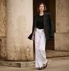 A woman walking in front of a stone column. Produktbild-Vorschau