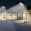 Street lights illuminate a residential street at night, with houses and garages visible. Voir les images du produit