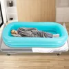 A man is lying in an inflatable bathtub on a bed. Náhled obrázku produktu