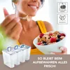 A woman is eating cereal from a bowl while several food storage containers are displayed in the foreground. Anteprima dell’immagine prodotto