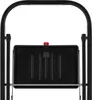 A close-up view of the top of a black step stool, showing the platform and a red locking mechanism. Podgląd zdjęcia produktu